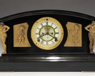 A turn of the century Ansonia "Monterey" model iron shelf clock.  8-day time and strike movement with two part porcelain dial, Roman numerals and visible escapement.  Iron case with cast panels and figural columns.  Restored finish, lacks rear cover, running when cataloged.  9 1/2" high.  ESTIMATE $200-300