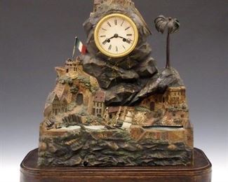 A 19th century French Castle form table clock with on demand music box and rocking ship.  8-day time and strike movement with silk thread suspension and painted metal dial with Arabic numerals.  Spelter case with original painted finish in the form of a hilltop castle above a river with silk "water" and two masted sailing ship.  Oak base with brass inlay and flattened ball feet.  Wear, losses, ship and music box spring broken, veneer damage to base, lacks glass dome, not currently running.  20" high overall.  ESTIMATE $600-800