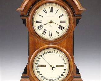 A late 19th century Seth Thomas "Parlor Calendar No. 4" model double dial clock.  8-day time and strike movement with lower calendar mechanism, painted metal dials with Roman/Arabic numerals.  Walnut case with arched, molded  top, shaped corbels, single long door and molded base.  Nicely refinished, replaced dials, running when cataloged.  24" high.  ESTIMATE $600-800