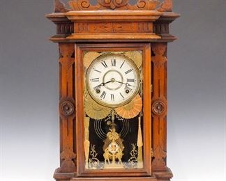 A late 19th century E. N. Welch "Liszt" model parlor clock. 8-day time and strike movement with painted metal dial, "Colby Wringer Co." cast pendulum.  Walnut case with shaped top and carved detail, single long door flanked by shaped columns, two darkened paper labels on backboard.  Older finish with some wear, surface grunge, running when cataloged.  23 1/4" high.  ESTIMATE $200-300 