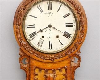 A late 19th century Anglo American short drop wall clock.  8-day time and strike movement wit painted metal dial.  Oak case with carved detail.  Older finish with minor wear, dial wear and some flaking, running when cataloged.  23 1/2" high.  ESTIMATE $100-200