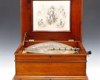 A turn of the century Regina disc music box.  Crank wind, double comb, mechanism plays 15 1/2" metal discs.  Includes eleven old and five modern discs.  Overhauled by the Meekins Music Box Co. in Florida.  Mahogany case with molded lift top, lower disc storage drawer and molded base.  Older refinishing with minor wear, some shrinkage, in good playing order.  22 3/4 x 20 3/4 x 12" high overall.  ESTIMATE $2,000-3,000