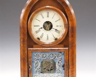 A 19th century Brewster and Ingraham "Beehive" shelf clock.  8-day time and strike movement with painted metal dial.  Figured Walnut case with a single shaped door and reverse painted lower glass.  Older finish with wear, small veneer flake, dial wear, paint flaking and later pendulum, running when cataloged.  18 3/4" high.  ESTIMATE $100-200
