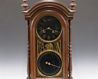 A late 19th century National Calendar Clock Co. "Fashion" model parlor clock.  8-day time and strike New Haven movement with simple calendar mechanism, Black painted metal dials with Roman/Arabic numerals.  Mixed wood case with arched molded cornice above a single door with painted "Fashion" glass flanked by turned columns on a molded base.  Older finish with wear, replaced finials, some dial wear, numerals enhanced on dials, running when cataloged.  32 1/4" high.  ESTIMATE $800-1,200