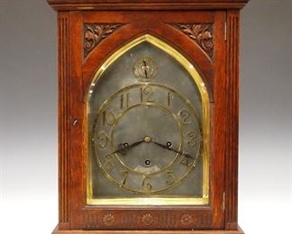 A late 19th century Lenzkirch bracket clock, retailed by Swinden & Sons, Birmingham (England).  8-day time and strike movement with Silvered dial and Brass chapter ring with Arabic numerals, quarter hour "Bim-Bam" striking on three gongs.  Serial #1 Million, 241841 indicates a date of 1899.  Oak case with molded Pagoda top, above a single door with carved detail and flat, fluted columns on a molded base with bracket feet.  Old finish with good color and slight wear, minor damage, running when cataloged.   21 3/4" high overall.  ESTIMATE $800-1,200