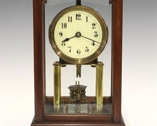 An early 20th century Gustav Becker 400 day table clock.  Brass time only movement with convex porcelain dial and Arabic numerals, with rotary pendulum.  Serial #2136713 with Becker anchor mark and "Medaille D'or" stamps on backplate.   Mahogany case with a molded top and base, arched beveled glasses.  Old finish with some wear, broken suspension spring, not running when cataloged.  12 1/4" high.  ESTIMATE $100-200
