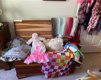 One of the two cedar chests with quilts and vintage doll