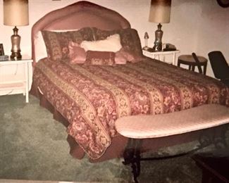 Queen bed with headboard; all bedding for sale.  Matching upholstery on the iron bench.  The black iron bench is called a fireside bench and is an antique. The wicker lamp tables are vintage white wicker.  Stool is needlepointed. All in very good condition.