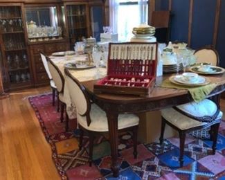 Dining table with 5 chairs, 6th chair is broken; wool rug; dishes