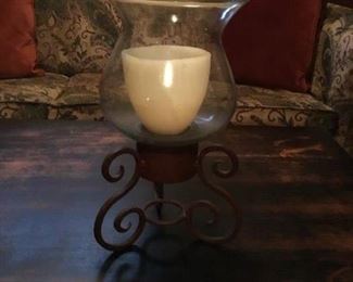 Hurricane style candle holder on wrought iron stand.