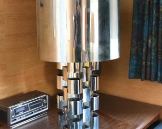 Item 29: Monumental Curtis Jeré Chrome Lamp $385 Minor dings in barrel shade. Base has had paint loss, spot repairs are visible. Some areas of chrome need to be polished after a deep clean.