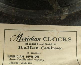 Item 58: Howard Miller for Meridian Wall Clock $295 Circa 1965, glazed ceramic, enameled aluminum. Signed with applied paper manufacturer's label to reverse: (Meridian Clocks Designed and Made by Italian Craftsmen in Ceramics Meridian Division Howard Miller Clock Company Zeeland, Michigan). One hand is missing, so repairs are needed.