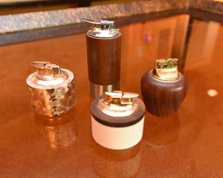 Item 64: Collection of Four Lighters $50 Three Ronson: The Norseman, Varaflame "La Ronde," and "Luralite." The fourth is marked "Genuine Teak"