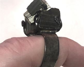 ITEM 85: Metal Chunk Ring $22 Open, flexible size sterling band, supports chunk of an unknown metal "crystal." Metal chunk is dark silver tone, but reflects some gold-tones under certain lights.