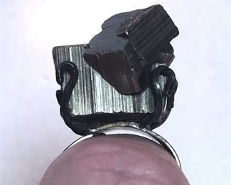 ITEM 85: Metal Chunk Ring $22 Open, flexible size sterling band, supports chunk of an unknown metal "crystal." Metal chunk is dark silver tone, but reflects some gold-tones under certain lights.