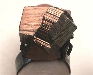 ITEM 85: Metal Chunk Ring $22 Open, flexible size sterling band, supports chunk of an unknown metal "crystal." Metal chunk is dark silver tone, but reflects some gold-tones under certain lights.
