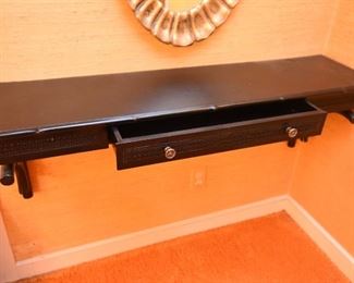 ITEM 115: Wall-mount black shelf $55 Faux bamboo trim, caned-look front panels. One drawer. Laminate on top is lifting on back left corner. Easily fixed with wood glue, a clamp, and 24 hours.