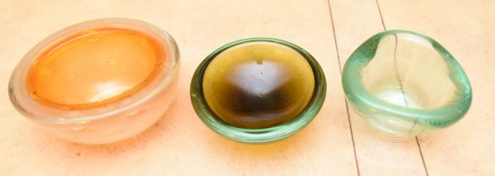 ITEM 120: Three Art Glass Bowls $55 L to R: Thick glass bowl with bubbles. The Interior has layers of orange glass and crackled gold encased in clear glass; green-brown shallow glass bowl; sea-green ribbed glass tri-form bowl.