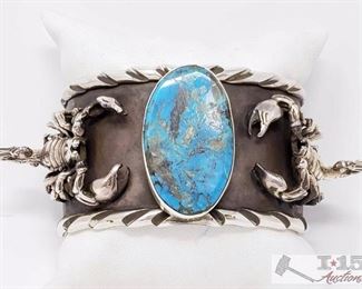 200: San Felipe Jacob Troncosa Sterling Silver Cuff Bracelet With Turquoise Value $2500.00
This is a magnificent Native American silver bracelet having a huge Pilot Mountain turquoise oval centered between 2 intricately hand carved silver scorpions on a large hand carved solid silver cuff with rounded hand carved silver borders! The inner cuff has silver hand stampings all around! Truly Stunning! The largest silver scorpion measures about 1-1/2" x 1". The center stone measures around 1-3/8" x 3/4". The width of the bracelet measures around 1-1/2". San Felipe artist, Jake Francosa. Sterling silver, marked. The inside end to end measures around 5-7/8" with an additional 1" gap. Sturdy 105 grams.Weighs Approx 106.8g
