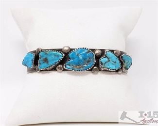 203 Very Rare Vintage Native American Navajo Carved Turquoise Sterling Silver Bracelet. Very Rare Vintage Native American Navajo Carved Turquoise Sterling Silver Bracelet
Value $875.00
This is a marvelous vintage Navajo very rare turquoise silver bracelet. This piece contains five beautiful hand carved turquoise stones that graduate in size towards the center. The stones are hand carved into arrowheads which is just amazing. Situated throughout the stones are wonderful large silver raindrops. Resting at the ends of the cuff are incredible silver shells. The center stone measures around 5/8" x 1/2". The width of the bracelet measures around 1/2". Signed by Navajo artist, Felly Eustace . Sterling silver. Cir. 1950's+. The inside end to end measures around 5-1/2" with an additional 1-1/4" gap. Sturdy 27 grams. 
 	 	 	 	 	 


 