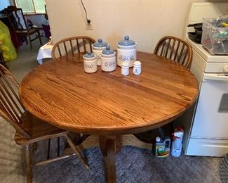 Round Oak dining table with four chairs, and one leaf