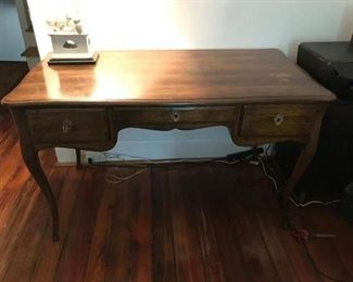 20th century French style desk, lovely dark wood with brass fittings (key included) and cabriole legs.  It measures 25 1/2" deep, 28 1/2" tall and 48" wide.  It is in overall good condition with a few minor color losses on the top.  Price: $300.00