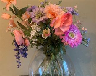 Faux flower bouquet in large glass dome vase 