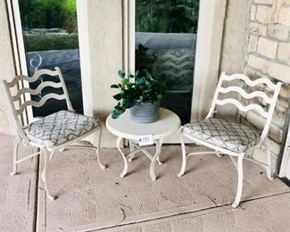 #131 ~ $200- Patio Set includes, 2 cream colored  wrought iron chairs w/ patterned seat cushions, 1 matching round end table, 1 ceramic pot with faux plant- Great condition, heavy!