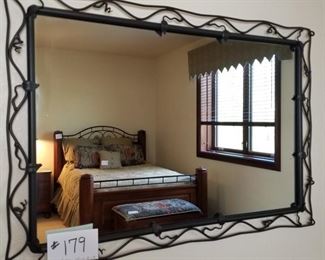 #179 ($50) ~ Black metal wall mirror with leaf and vines frame.  Measures 40" x 28". 