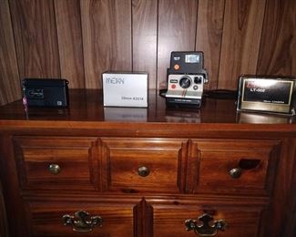 Top of dresser of 1980s bedroom set is pictured, vintage cameras also