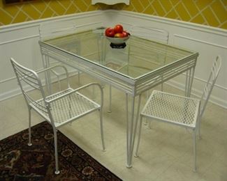 wrought iron table with glass insert, 3 side chairs and one arm chair