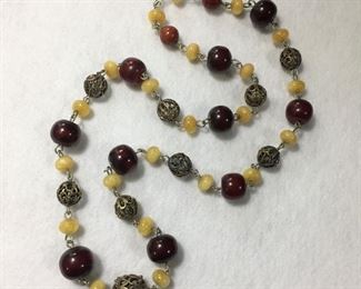 Vintage funky, eclectic 32" L necklace with with amber and butterscotch resin beads and hook and eye clasp. $96
