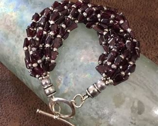 Stunning 7 3/4"  artisan-made 10-strand beaded garnet bracelet with sterling silver beads and sterling silver toggle clasp.  $110
