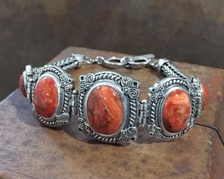 Stunning Thai sterling silver and coral link bracelet with toggle clasp. Flexible length of 7 1/2" to 8". Stamped THAILAND 925 and signed NK.  $140
