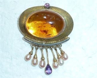 Lovely amber, amethyst, and pearl brooch or pendant.  It is set in sterling silver with gold accents.   Truly exquisite. It measures 1 7/8" long by 1 1/4" wide.   $88