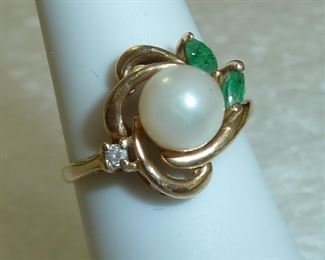 14k gold and large 7mm pearl with diamond and emerald accents.  All stones are real.  One emerald has a crack across it, but it is not visible to the naked eye.  Really pretty ring.  $250