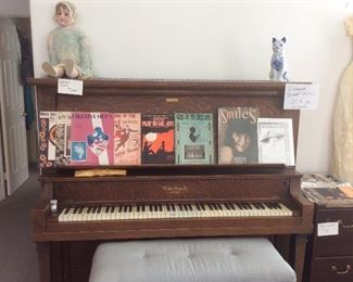 Antique tiger oak piano with ivory keys, vintage doll and sheet music