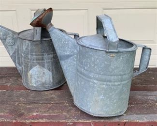 Old watering cans. Great for garden decor, with flowers or for its general use. These are old metal ones. One has the spot attachment and one does not. The one with the spout attachment is $28 and the other is $22. They each measure approximately 15" x 14"