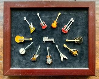 Collection of Gibson Guitar collectible pins adhered to velvet board in wood frame. Gibson logo center pin. $20 (Price reduced from $28)