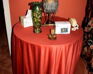 Large side table with tablecloth, brass lamp, antique green glass vase
