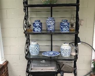 One of two bakers racks on patio used to display garden pottery.  Both wrought iron with glass shelves.
(SOLD Blue White Ginger Jars)