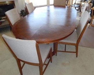#13 - $350 - Mid Century Modern Table with (6) Chairs - Has two leaves - In good condition - one chair has some damage underneath (see picture) Measures: 7' long with both leaves in 4' without leaves