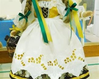 $40.  SCHNEIDER HANDMADE GERMAN PORCELAIN DOLL ON STAND WITH ORNATE CLOTHING.