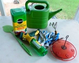 $30.  7 ASSORTED GARDENING TOOLS AND STUFF.  INCLUDES A WATERING CAN, FULL CONTAINER OF MIRACLE-GRO PLANT FOOD, PLANT SPRAYER, HUMMINGBIRD FEEDER, FLY SWATTER, GARDENING GLOVES AND A SMALL HAND RAKE. 