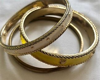 $25 Set of three enameled bracelets, one yellow and two off-white  