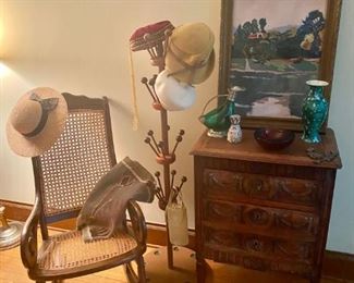 This exquisite petite carved chest is giving us life! Please note also the naive impressionistic painting, cane rocker, stick and ball hat stand, and pottery.