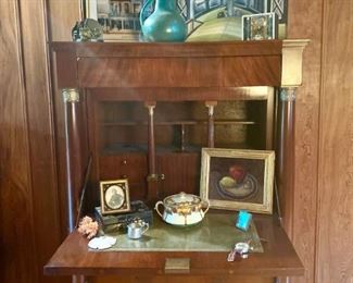 Lovely Empire secretary, smooth mahogany, brass hardware wonderfully patinated.  Ancestral tintype, OOB still life in lemon gold frame, mid century glazed pitcher, unsigned American modernist OOC, architectural print, brass captain's wheels bookends. 