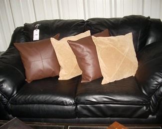 Black leather love seat , pillows sold separately 