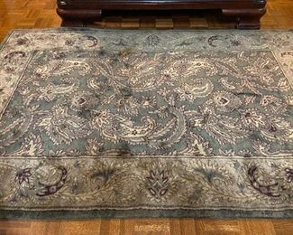 Dark green and earth toned area rug.