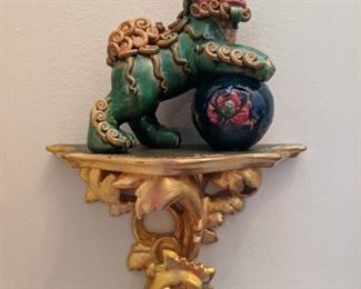 One of  pair of gold gilt wooden wall sconces, with L-R facing ceramic Asian foo dogs, flanking the front door.